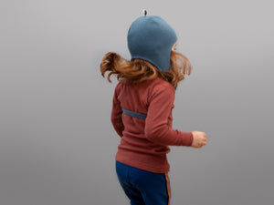 blaue Mütze aufgesetzt Kind hüpft